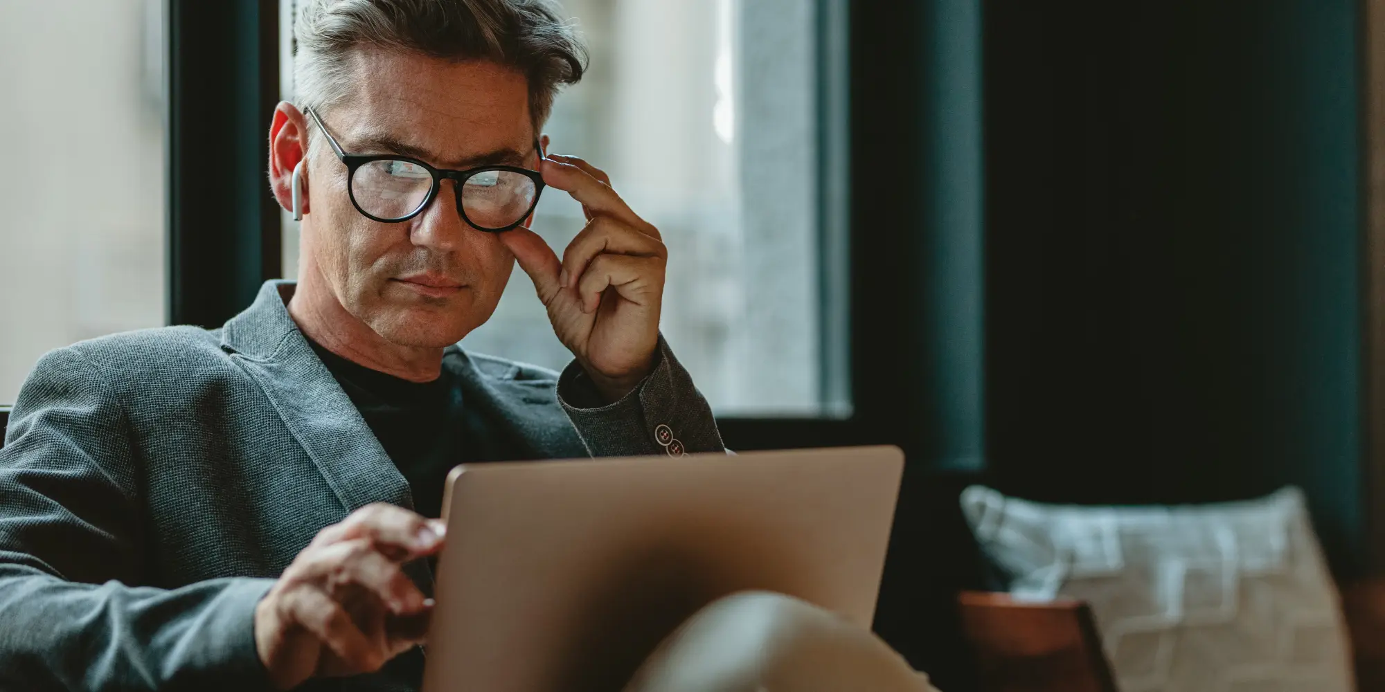 Man Adjusting Glasses Using Tablet - 1031 Luxury Exchange